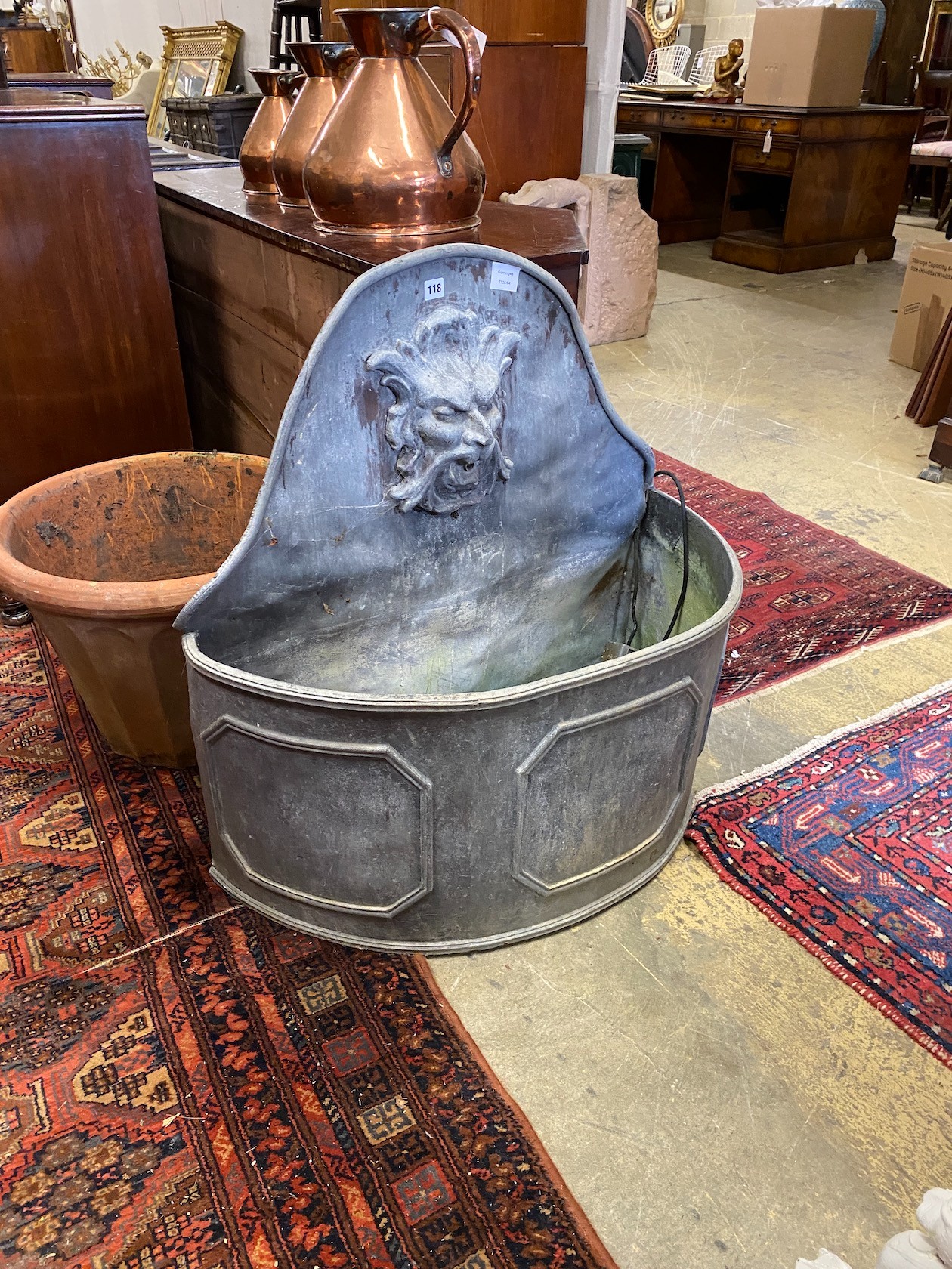 An early 18th century style 'D' shaped lead cistern with mask spout, width 80cm, depth 36cm, height 80cm